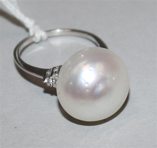 A 10ct white gold lareg baroque cultured pearl dress ring with diamond set shoulders, size O.